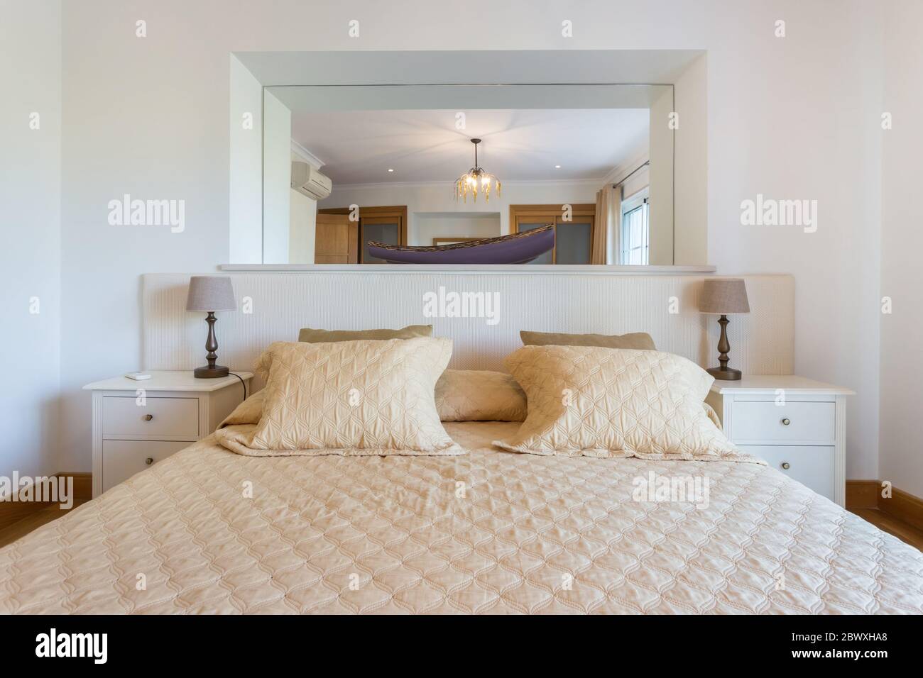 Schönes modernes Schlafzimmer mit einem großen Spiegel an der Wand. Europäisches Hoteldesign. Nahaufnahme. Stockfoto
