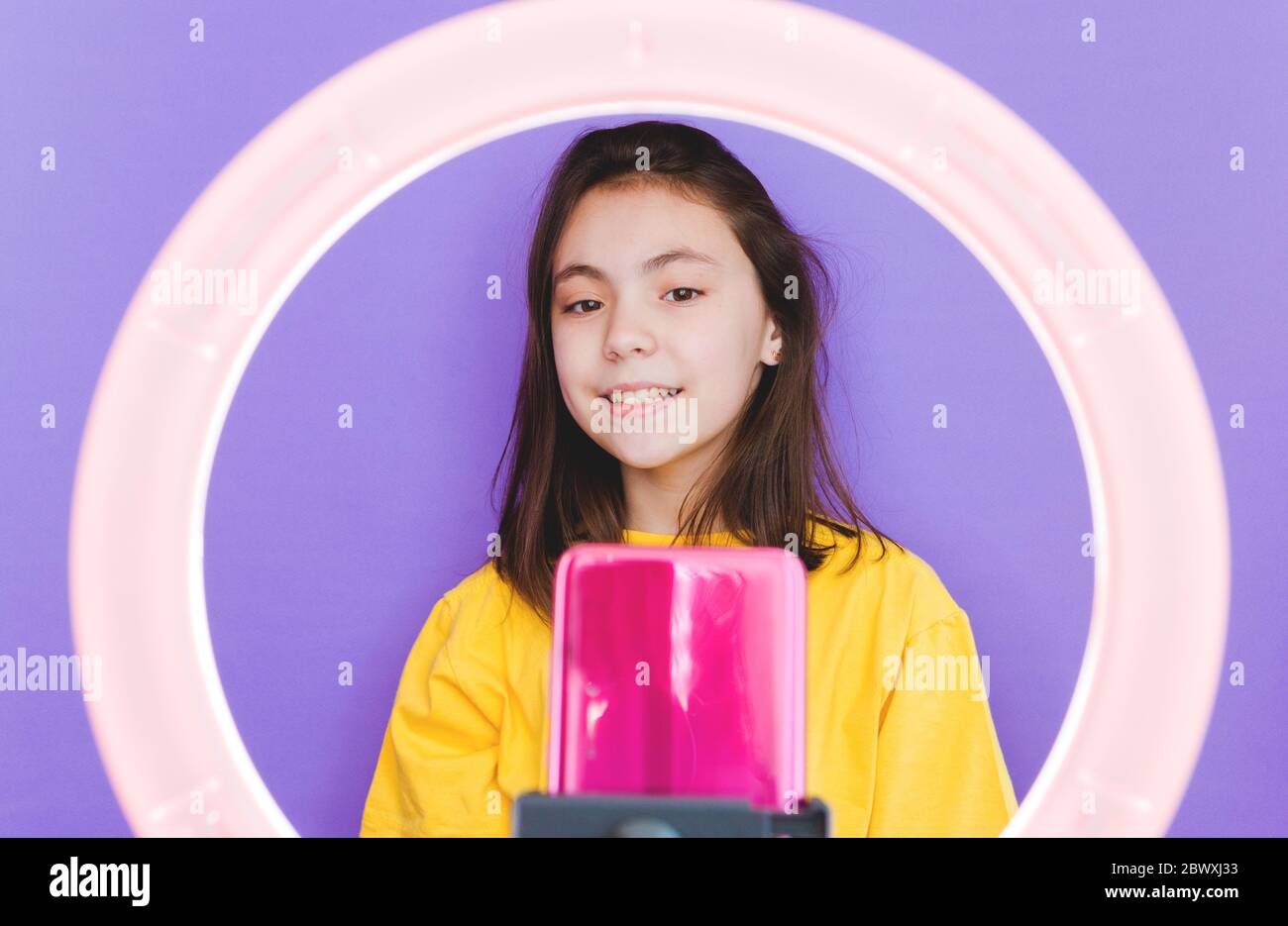 Eine Bloggerin spricht mit Abonnenten, leitet eine Live-Übertragung, schaut auf den Smartphone-Bildschirm. Führen Sie einen Videoanruf an Freunde und Eltern. Soziale Netzwerke Stockfoto