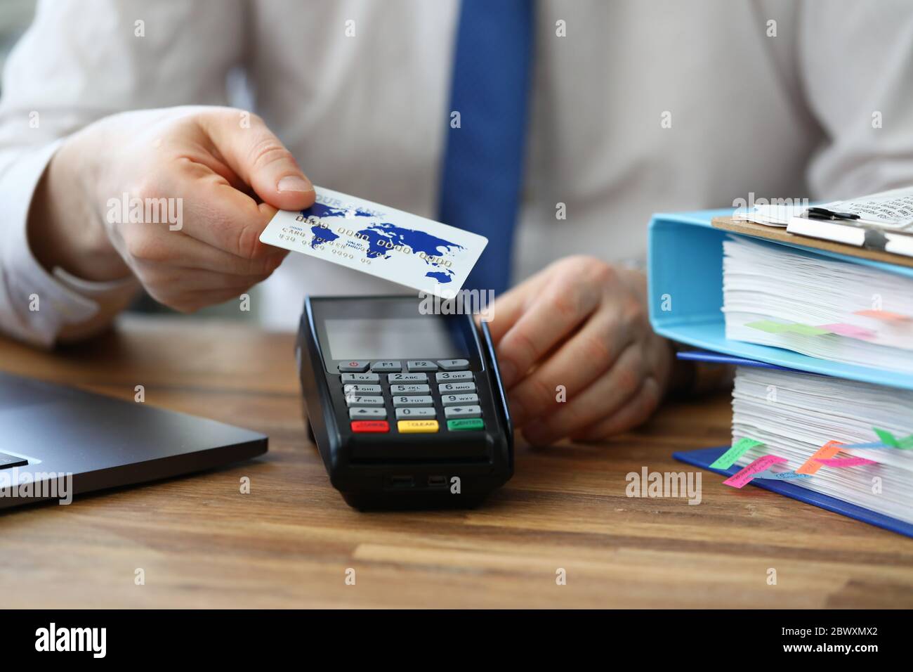 Büroangestellte zeigt Kreditkarte und Terminal Stockfoto