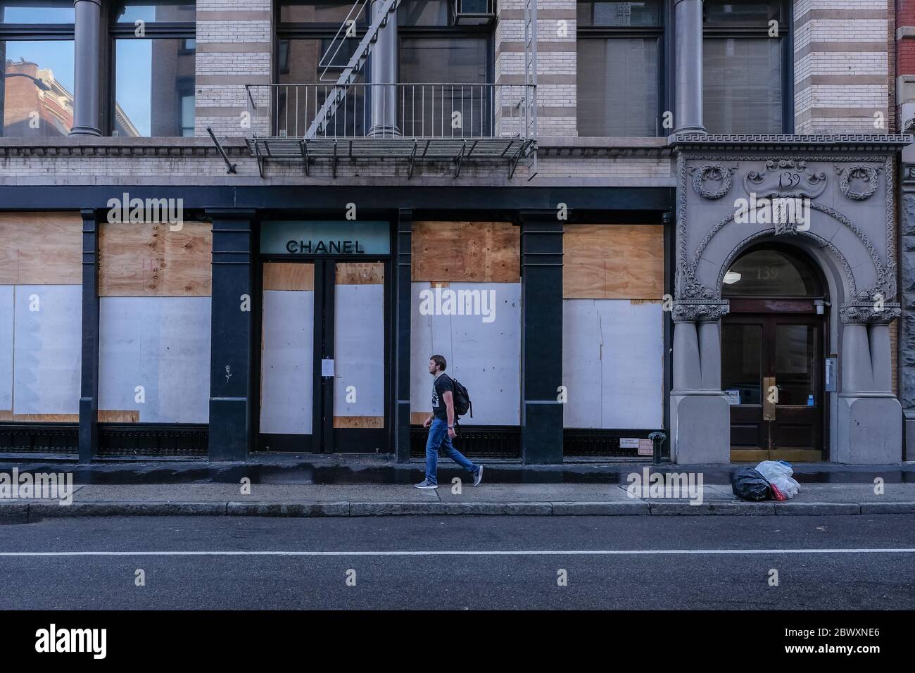 Ein Mann geht am Morgen nach dem achten Tag der Proteste von George Floyd in New York City an einem aufgetanteten Chanel-Laden in SOHO, in Lower-Manhattan vorbei. Stockfoto