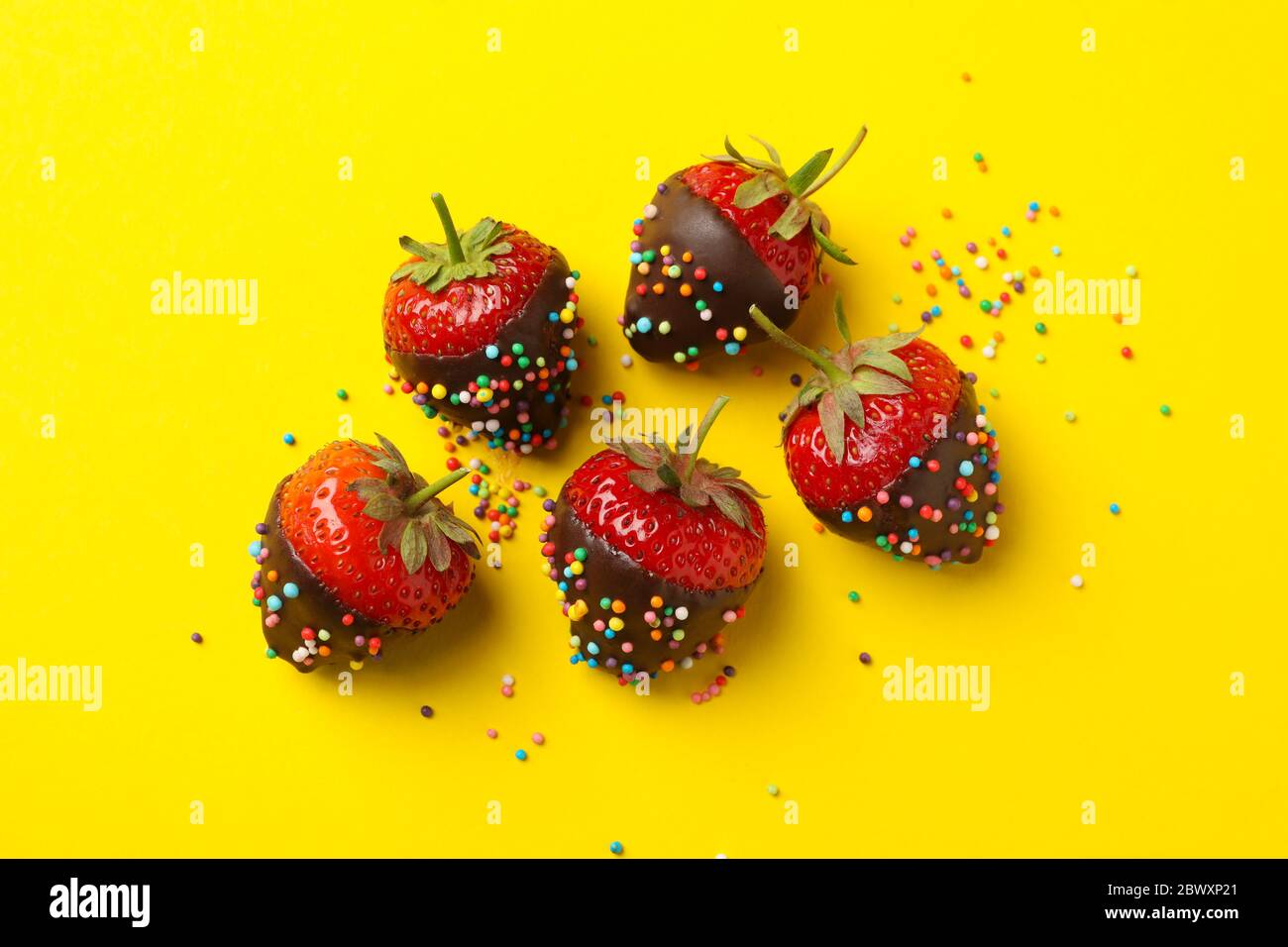 Schokoladenfondue. Erdbeere in Schokolade auf gelbem Hintergrund Stockfoto