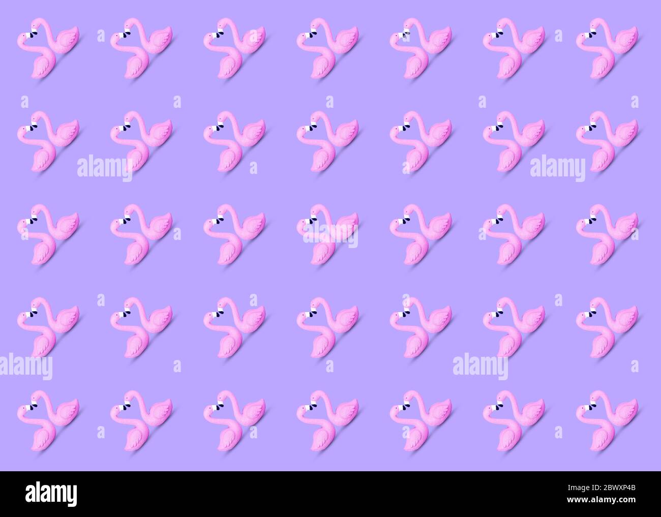 Trendy Sommer nahtlose Muster aus einem niedlichen rosa Spielzeug Flamingo Paar Schwimmen auf einem violetten Hintergrund gemacht. Beliebtes Vogelsymbol des Sommers. Entspannend und c Stockfoto