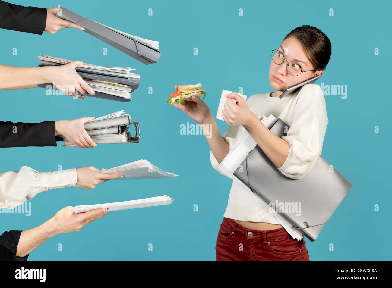 Schockierter Büroangestellter schaut weg, während er Kaffee und ein Sandwich hält. Kollegen und Vorgesetzte verteilen ihr Ordner mit Dokumenten, wodurch sie sich in die andere Richtung Stockfoto