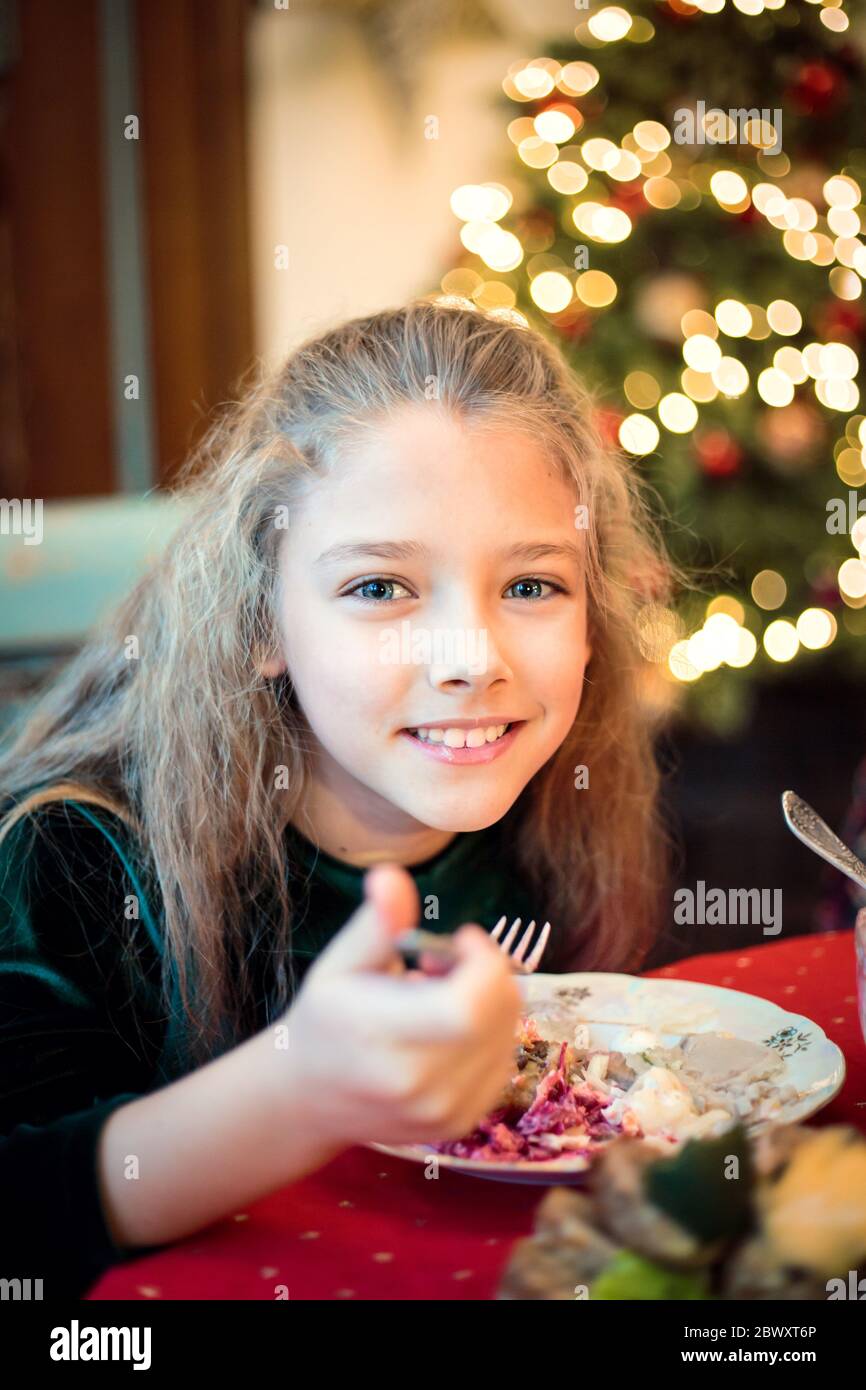 Kleines Mädchen, Teenager-Tochter an einem festlichen Weihnachts- oder Neujahrstisch. Stockfoto