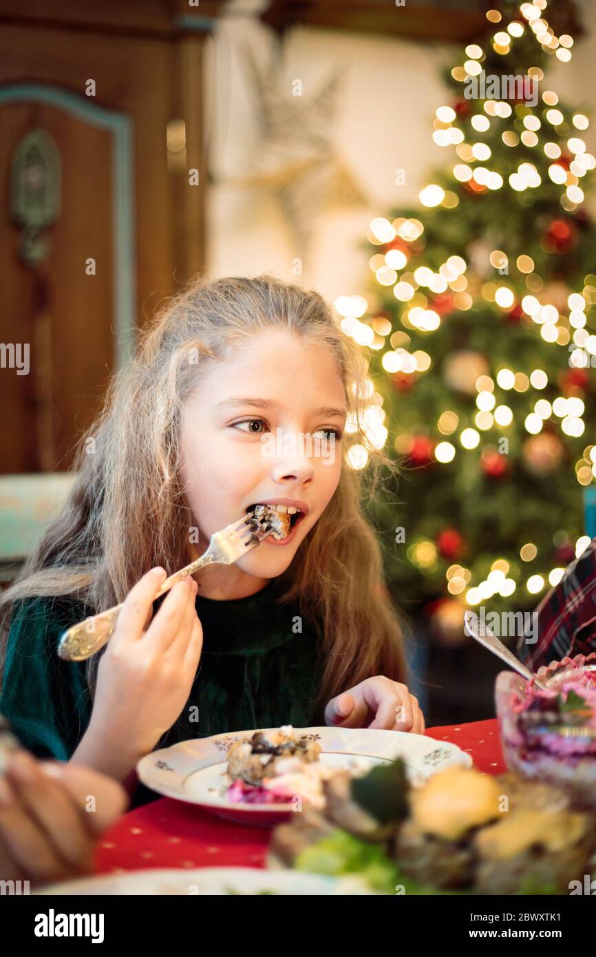 Kleines Mädchen, Teenager-Tochter an einem festlichen Weihnachts- oder Neujahrstisch. Stockfoto