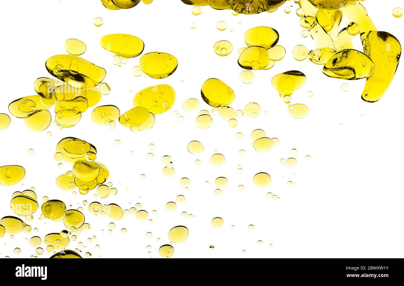 Tropfen Olivenöl. Abstraktes Bild von Blobs von goldenem Öl schwebend im Wasser. Nahaufnahme Blasen auf weiß isoliert Stockfoto