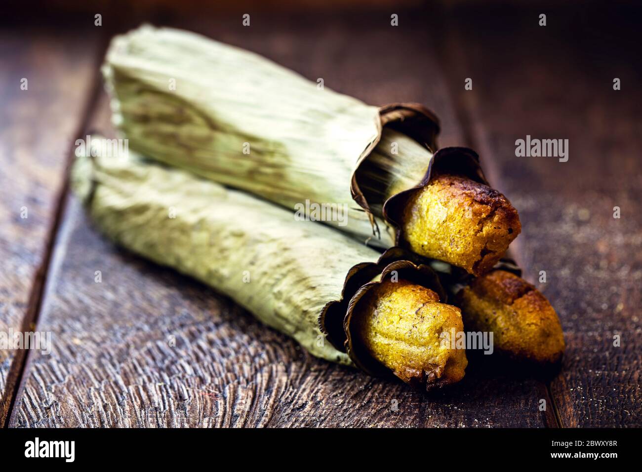 Broa mit Mais und in Bananenblatt eingewickelt. Maisbrot für die Juni und Juli Parteien in Brasilien gemacht. Brasilianische Küche. Stockfoto