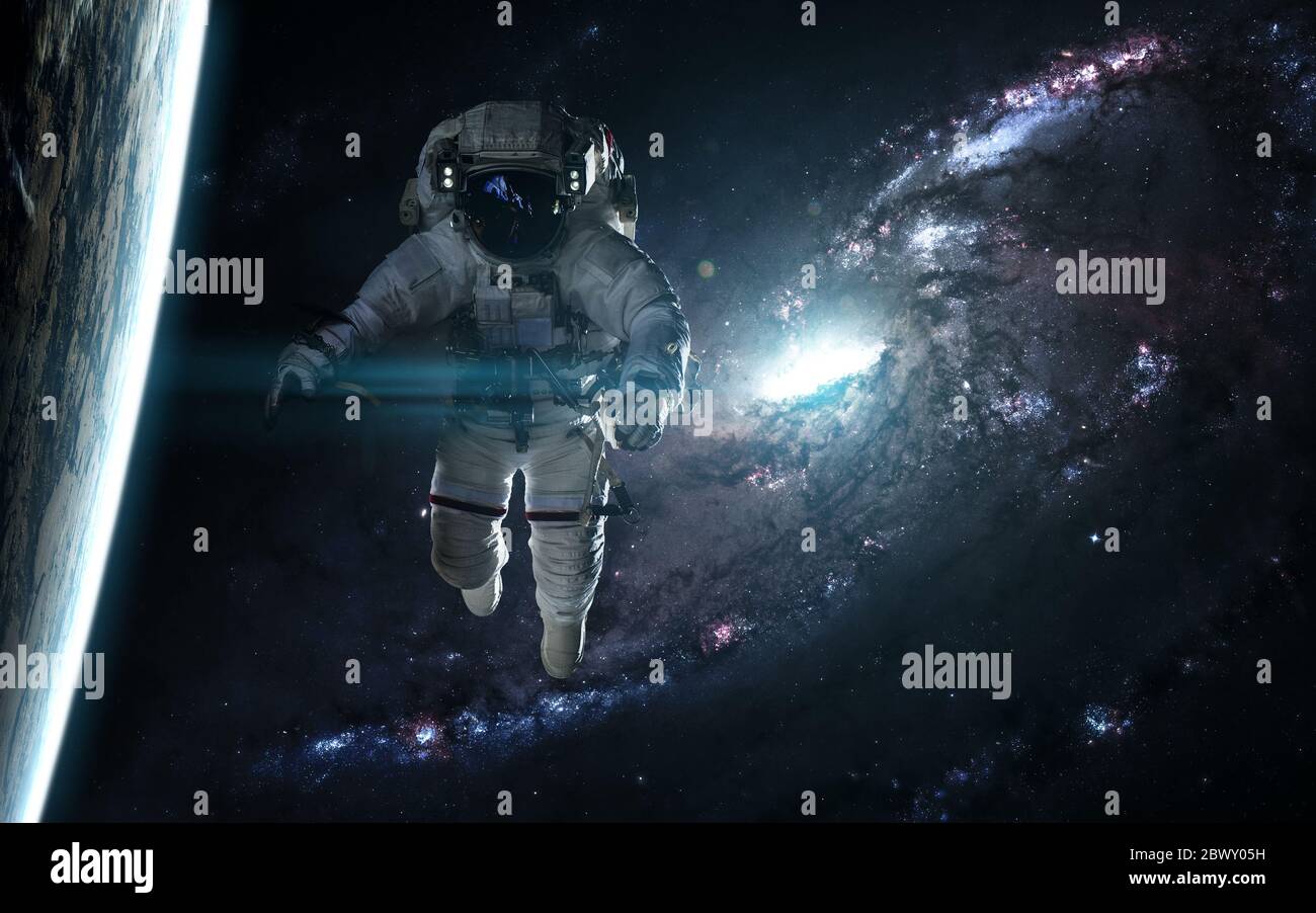 Astronaut und Planet gegen eine blaue Galaxie Stockfoto