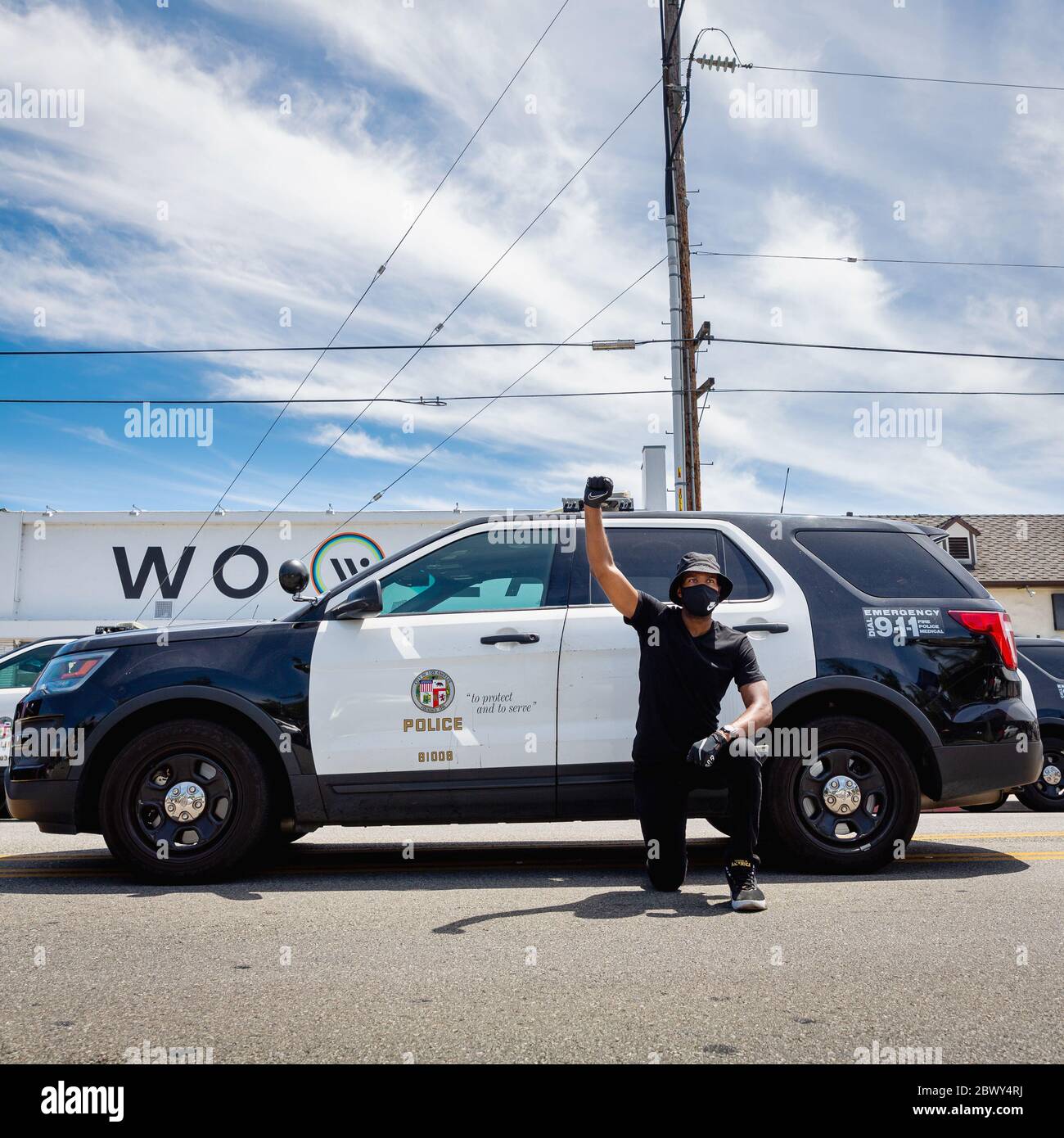 Mann, der vor dem Polizeiauto kniet, protestiert gegen die Ermordung von George Floyd: Fairfax District, Los Angeles, CA, USA, 30. Mai 2020 Stockfoto