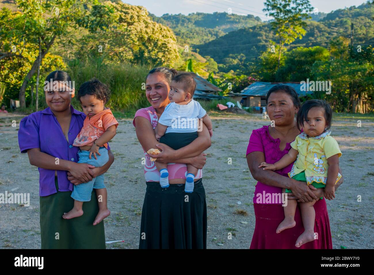 Maya-Frauen, die kleine Kinder im Dorf La Pinta in der Nähe von Copan, Honduras, tragen. Stockfoto