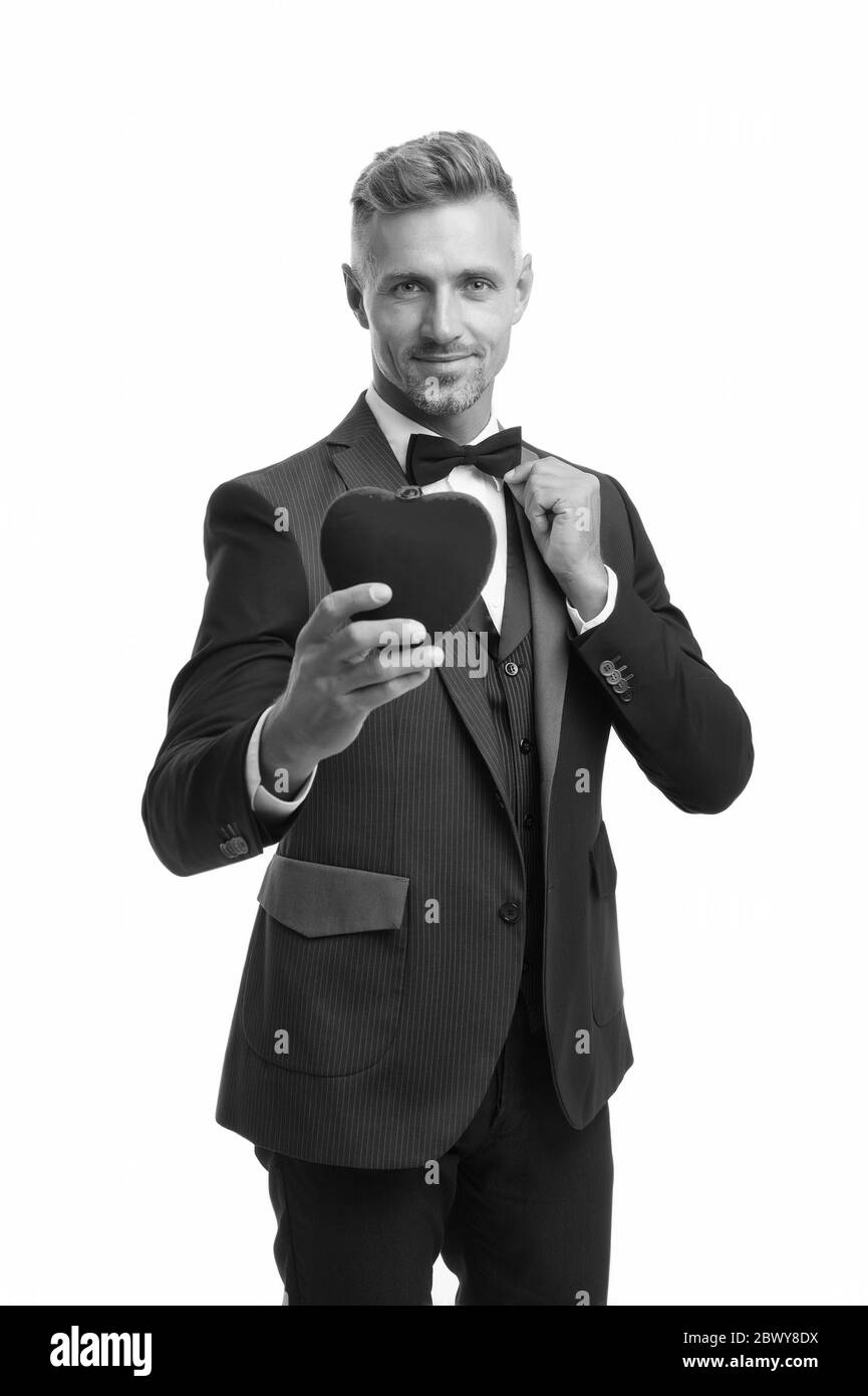 Liebe wird gefeiert. Tuxedo Mann rot Valentines Herz. Bereit für ein romantisches Datum. Besonderer Anlass. Eleganter selbstbewusster Mann isoliert auf Weiß. Business formales Outfit. Liebessymbol am Valentinstag. Stockfoto