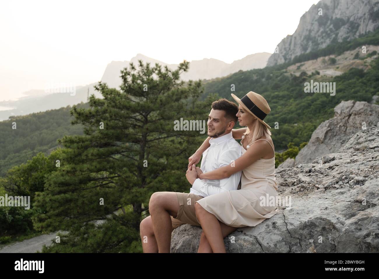 Junges Paar in der Liebe sitzen auf Rock am Abend, schöne Dämmerung. Stockfoto