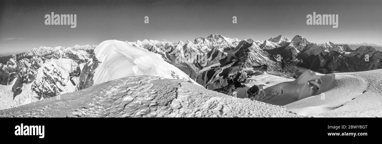 Nepal. Wanderung zum Mera Peak. Panorama der Himalaya-Gipfel vom Gipfel des Mera Peak auf 6476m, Blick in Richtung Mount Everest 8848m der höchste Berg der Welt dominiert den Mittelhorizont, rechts ist Makalu 8463m der Rote Berg und der fünfthöchste Berg der Welt, Rechts vor dem Makalu liegt Chamlang, dann am rechten Horizont über 100 Meilen entfernt ist der Kangchendzönga 8586m, der dritthöchste Berg der Welt. Im Vordergrund ist der verschneite Mera La Passsattel zu sehen Stockfoto