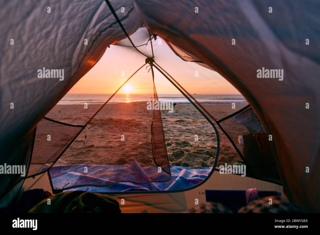 Blick durch die Tür öffnen von orange und grau Zelt Camping Sommer Strand Hintergrund am Morgen. Stockfoto