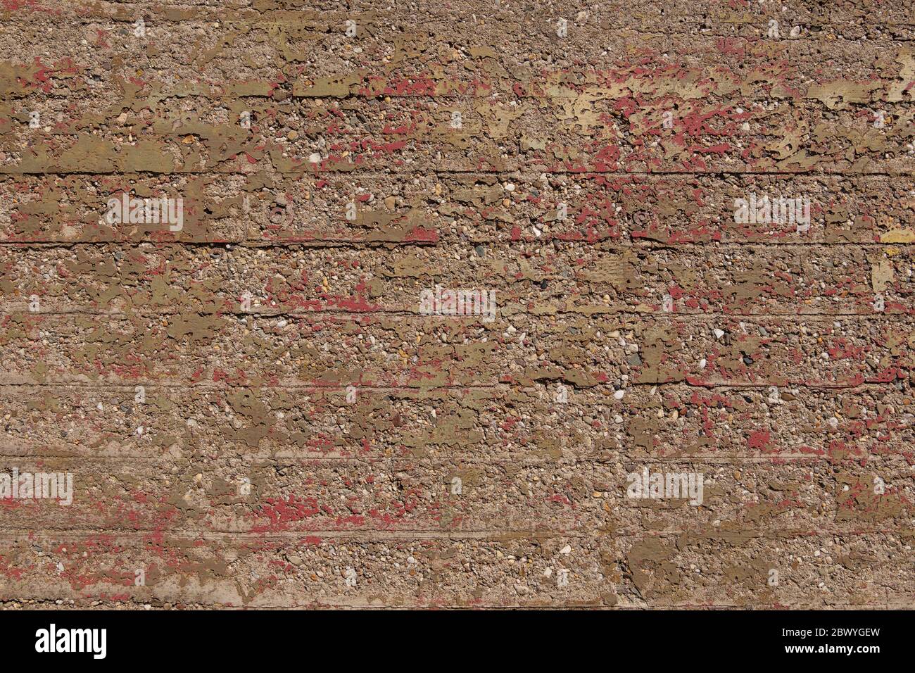 Old Raw Grunge raue holprige Betonstruktur mit verbleibenden Kratzer der rot lackierten und korrosiven Oberfläche. Struktur des äußeren alten Bunkers. Stockfoto