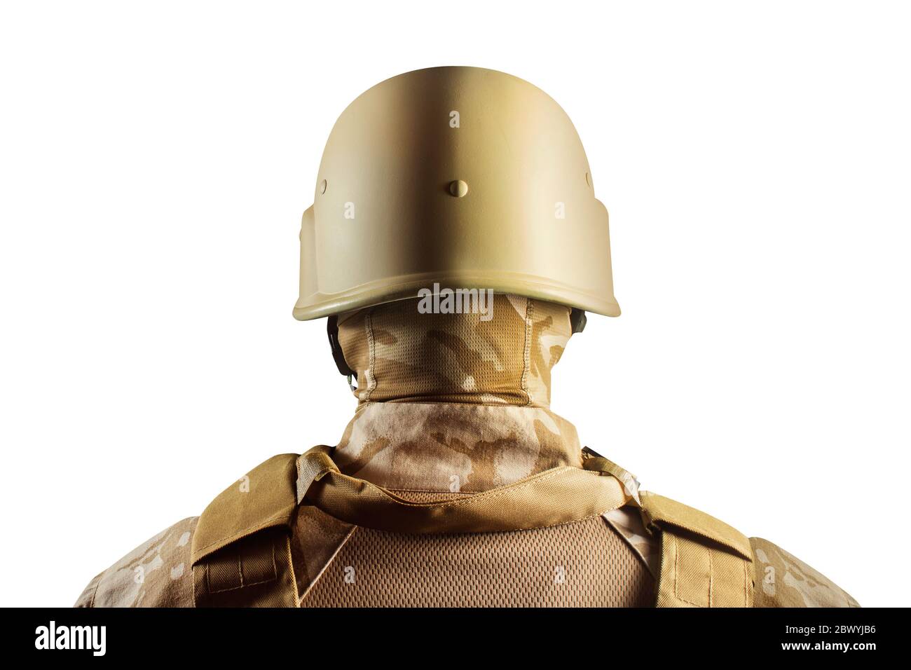 Isoliertes Foto eines Soldaten in Wüstenuniform, der im Helm steht. Stockfoto
