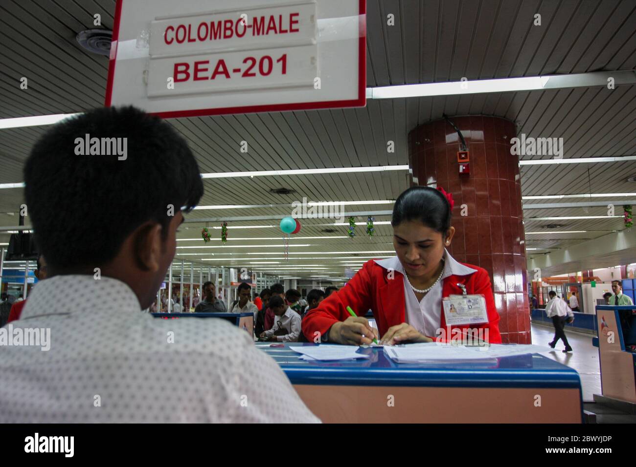 Arbeitsmigranten an den Check-in-Schaltern am internationalen Flughafen Hazrat Shah Jalal in Dhaka, Bangladesch. Stockfoto