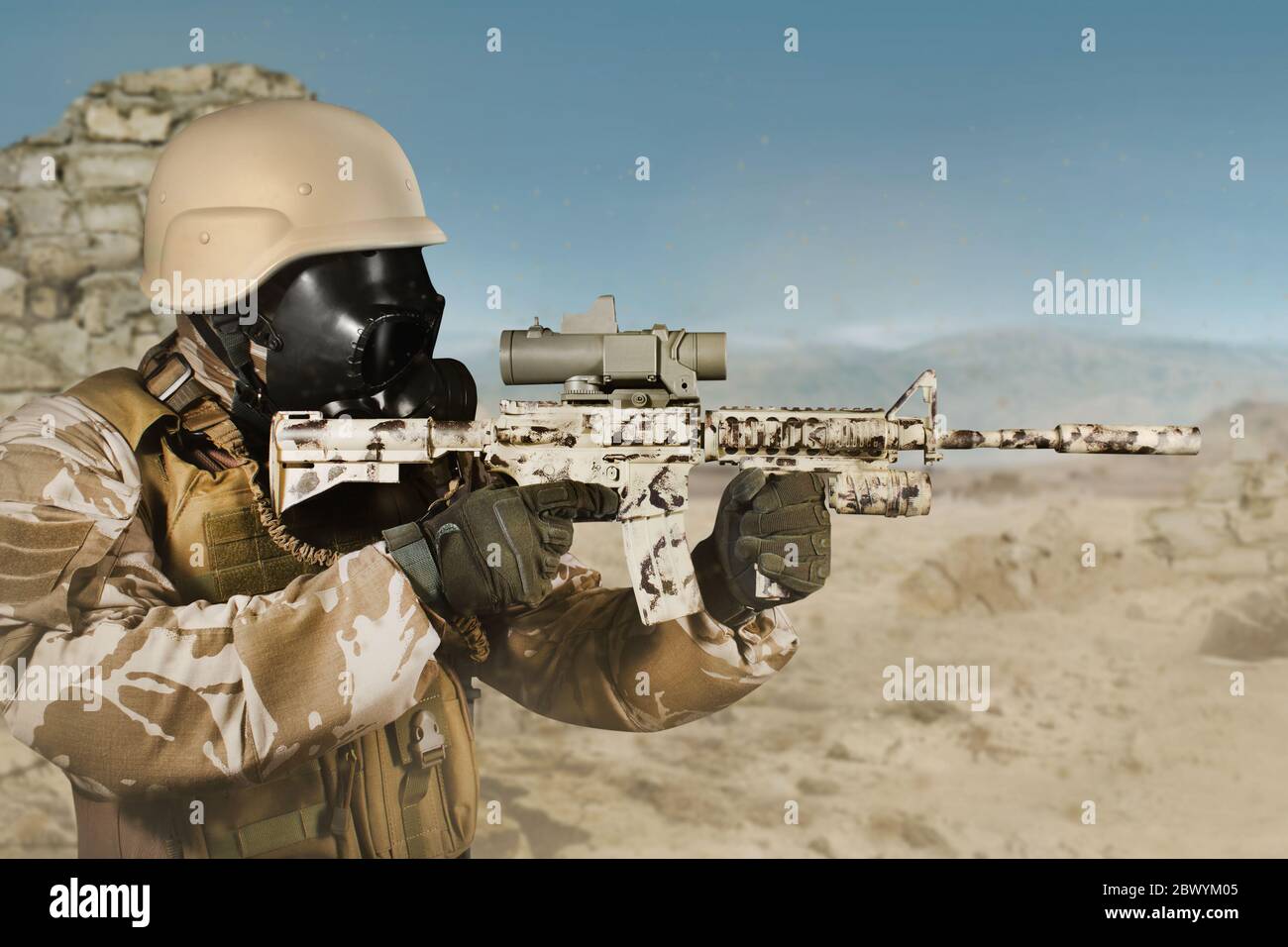 Foto von einem voll ausgestatteten Soldaten in Uniform, Rüstung, Helm und Gasmaske mit Gewehr in Wüste Schlachtfeld stehend Hintergrund Profilansicht. Stockfoto