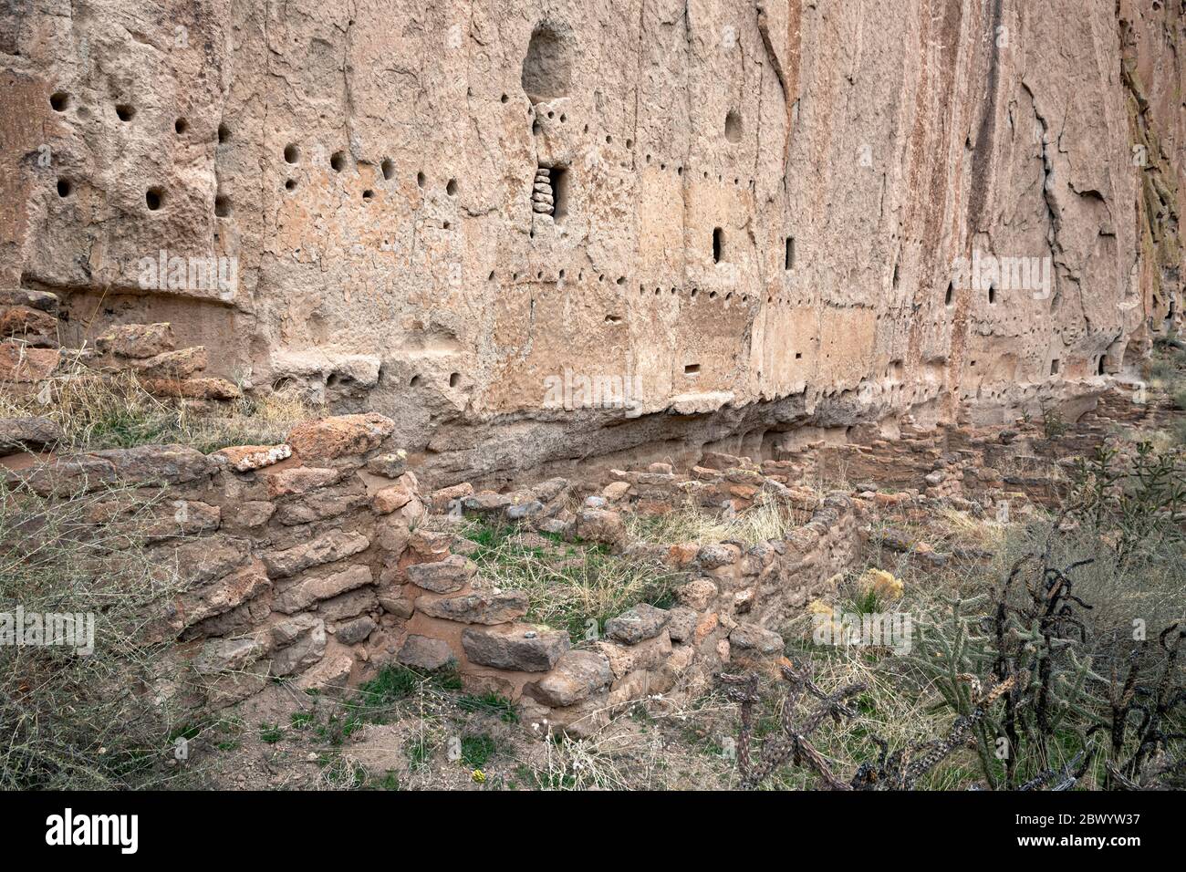 NM00465-00...NEW MEXICO - Antike Fundamente am Fuß einer Klippe mit Löchern, die in den Stein gebohrt wurden, um Dächer und Böden am Long House zu stützen. Stockfoto