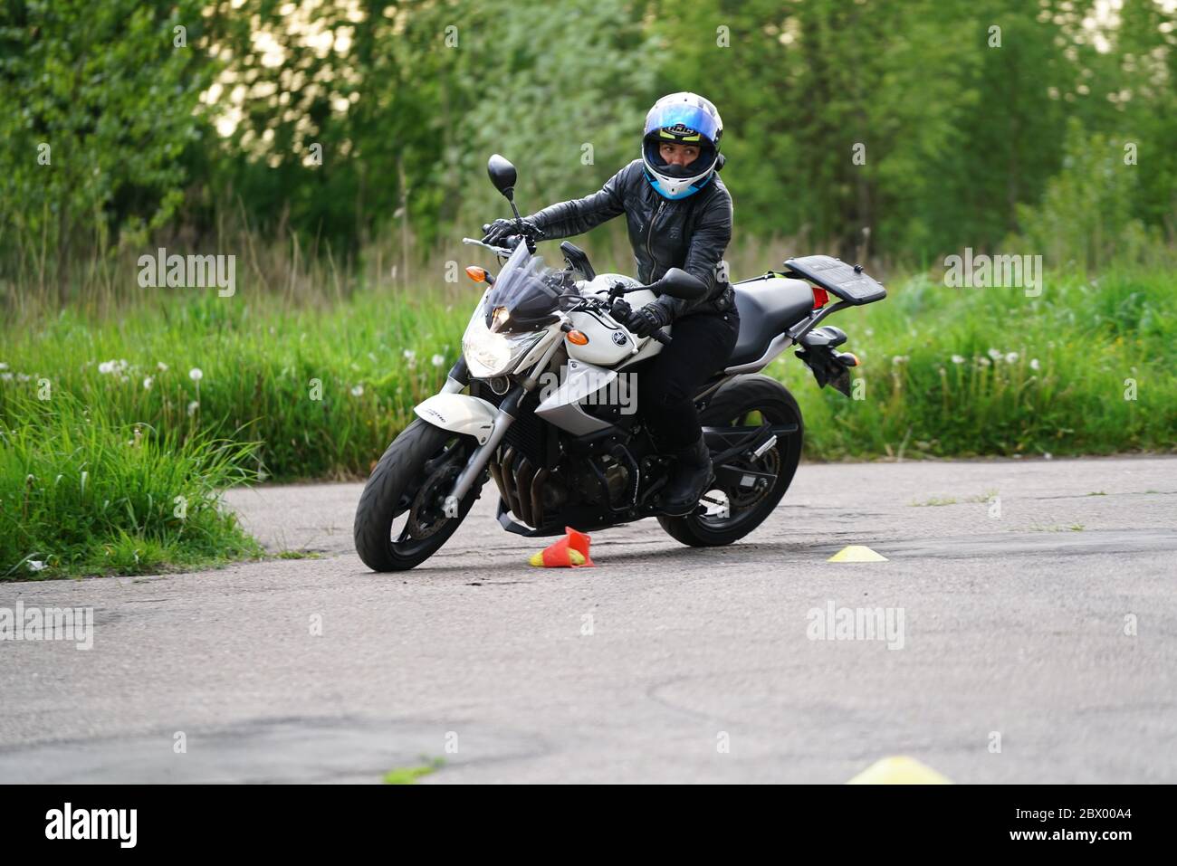 25-05-2020 Riga, Lettland. Motorradfahrer fährt auf Straße, Seitenansicht, Nahaufnahme. Stockfoto