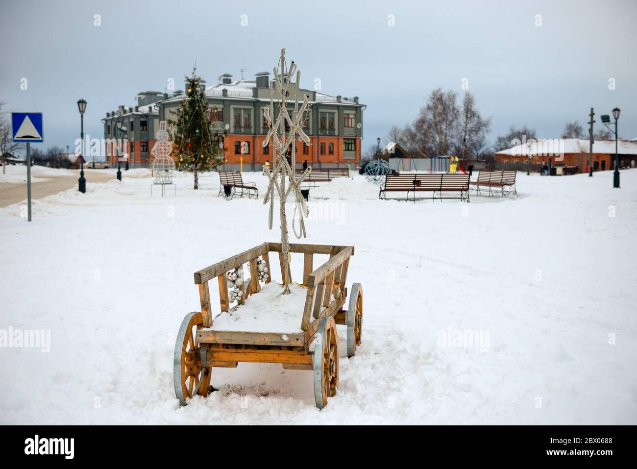 Rustikaler Wagen mit leuchtender Weihnachtsdekoration in Form einer Schneeflocke Stockfoto
