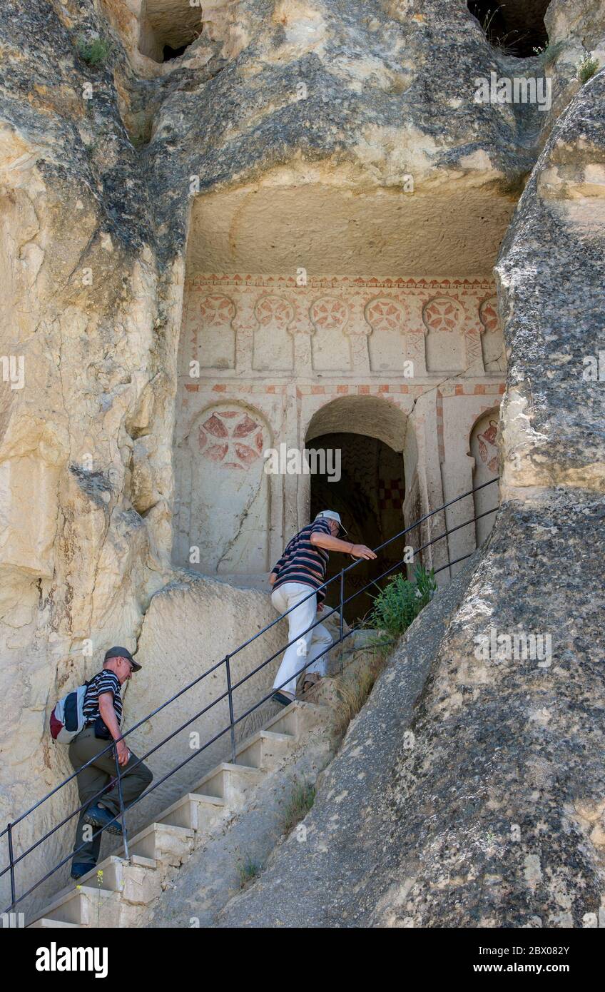 Besucher des Freilichtmuseums in Goreme in der Region Kappadokien in der Türkei steigen die Treppe hinauf, um die alte Kirche der Heiligen Barbara zu betreten. Stockfoto