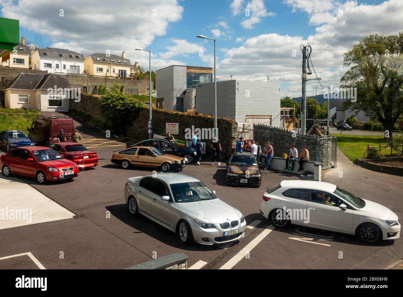 Eine Gruppe junger Männer mit zahlreichen umgebauten Autos, die in den Straßen der kleinen Stadt im ländlichen Irland herumhängen und Spaß haben. Stockfoto