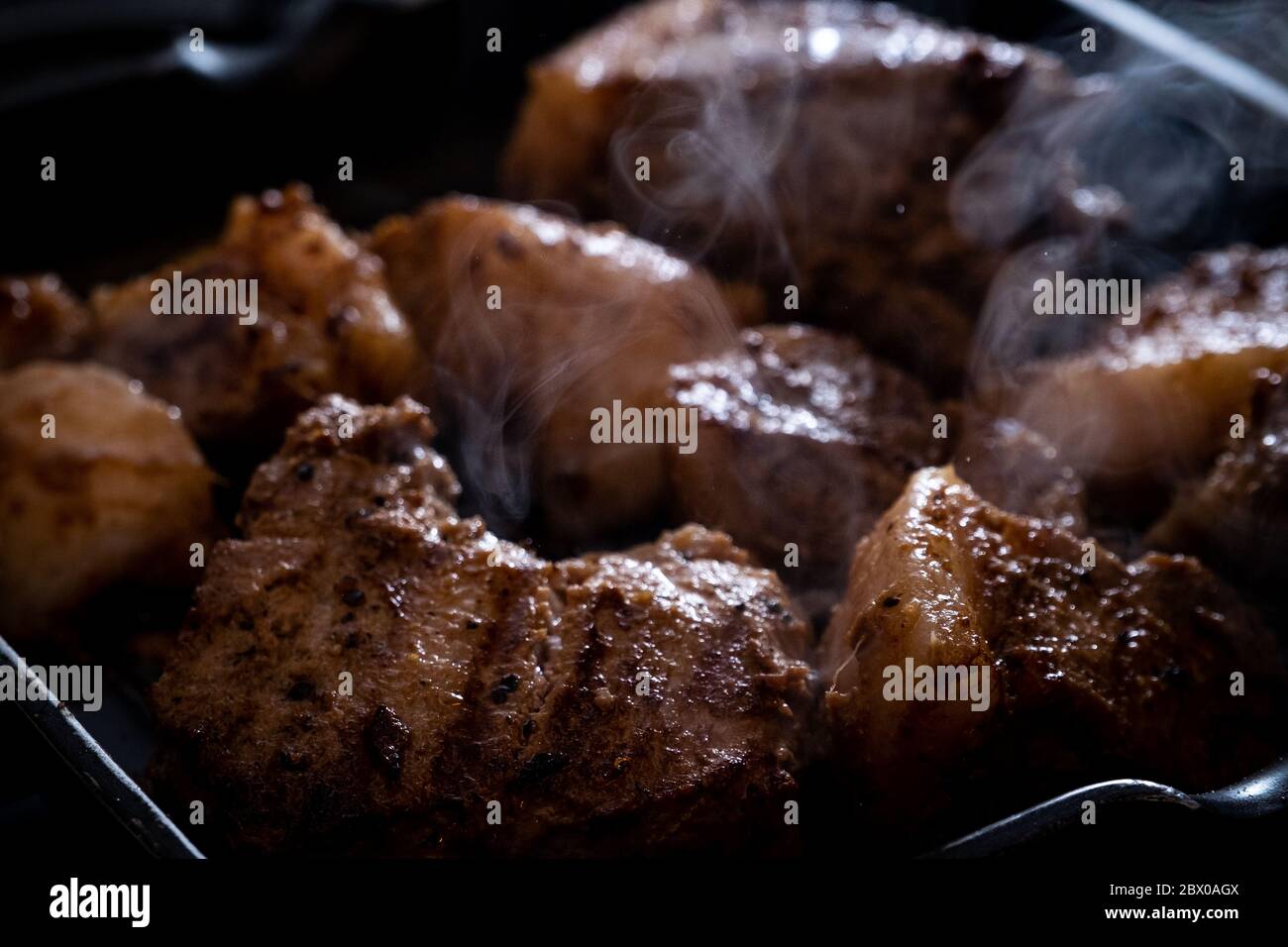 Gegrillte Pfanne gebratene Schweinebäcken mit Rauch launisch dunkles Foto Stockfoto