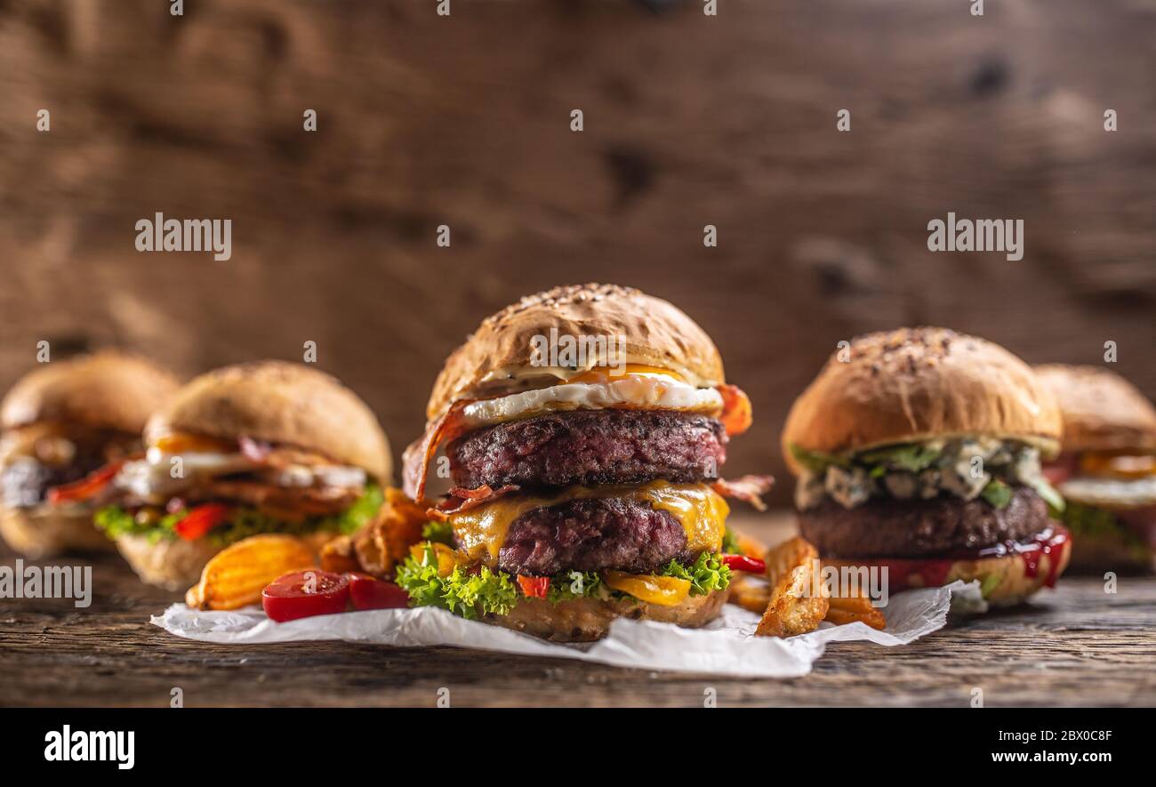 Auswahl an verschiedenen frischen, leckeren Burgern in rustikalem Ambiente Stockfoto