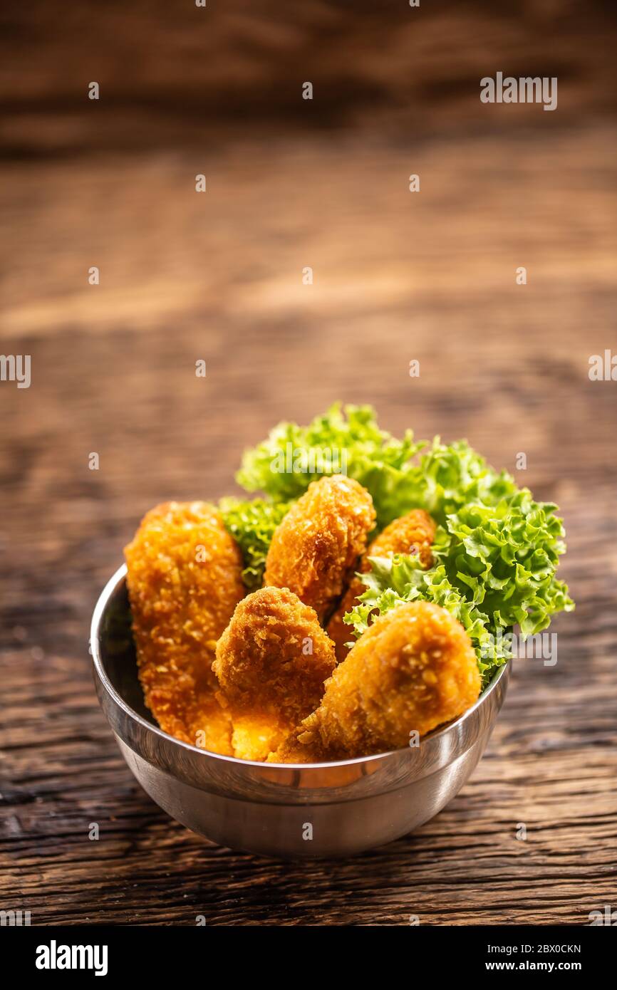 Hühnchen Nuggets mit Salat in einer Metallschüssel auf einer rustikalen Holzoberfläche Stockfoto