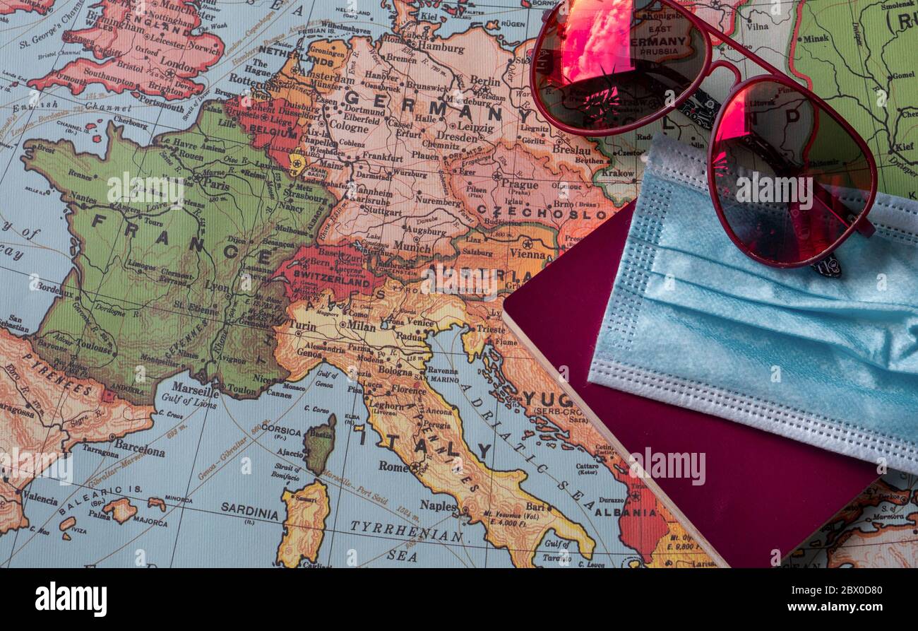 Rote Sonnenbrille, eine blaue OP-Maske und ein Pass auf einer Europakarte. Konzept des Urlaubs nach der COVID-19 Pandemie im Jahr 2020 Stockfoto