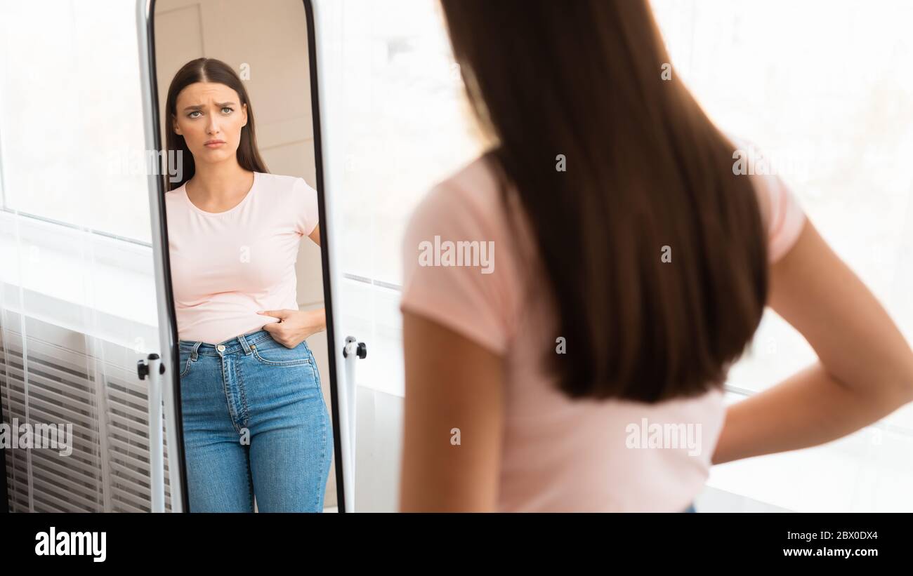 Verärgert Frau Berühren Fett Bauch Suchen In Spiegel Innen, Panorama Stockfoto