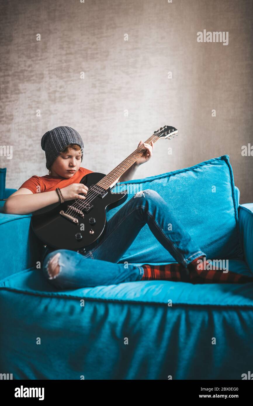 Melancholischer rothaariger Junge, der eine traurige Melodie auf einer E- Gitarre spielt Stockfotografie - Alamy