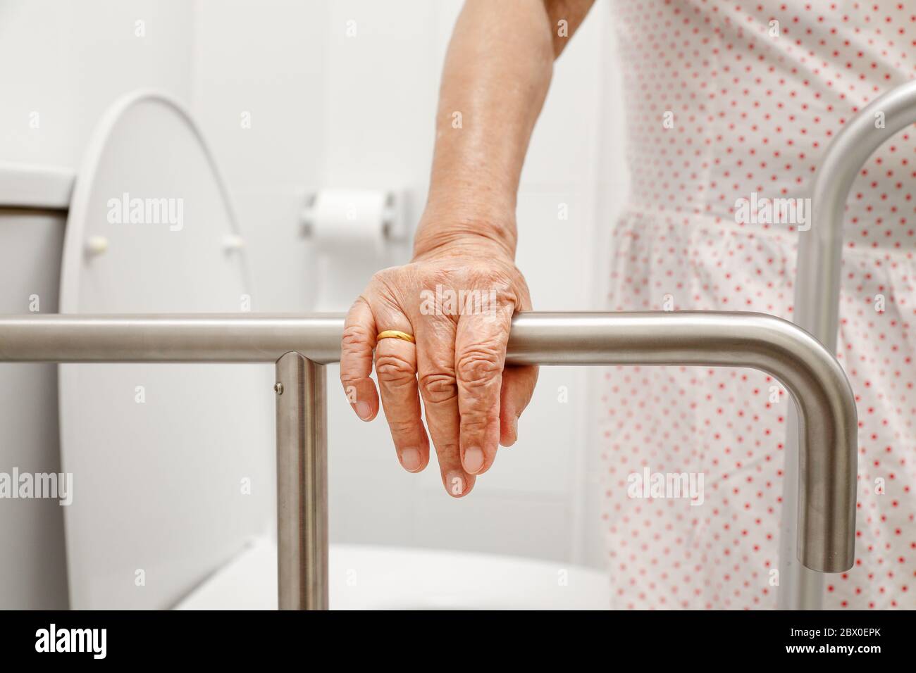 Ältere Frau, die auf dem Geher in der Toilette hält. Stockfoto