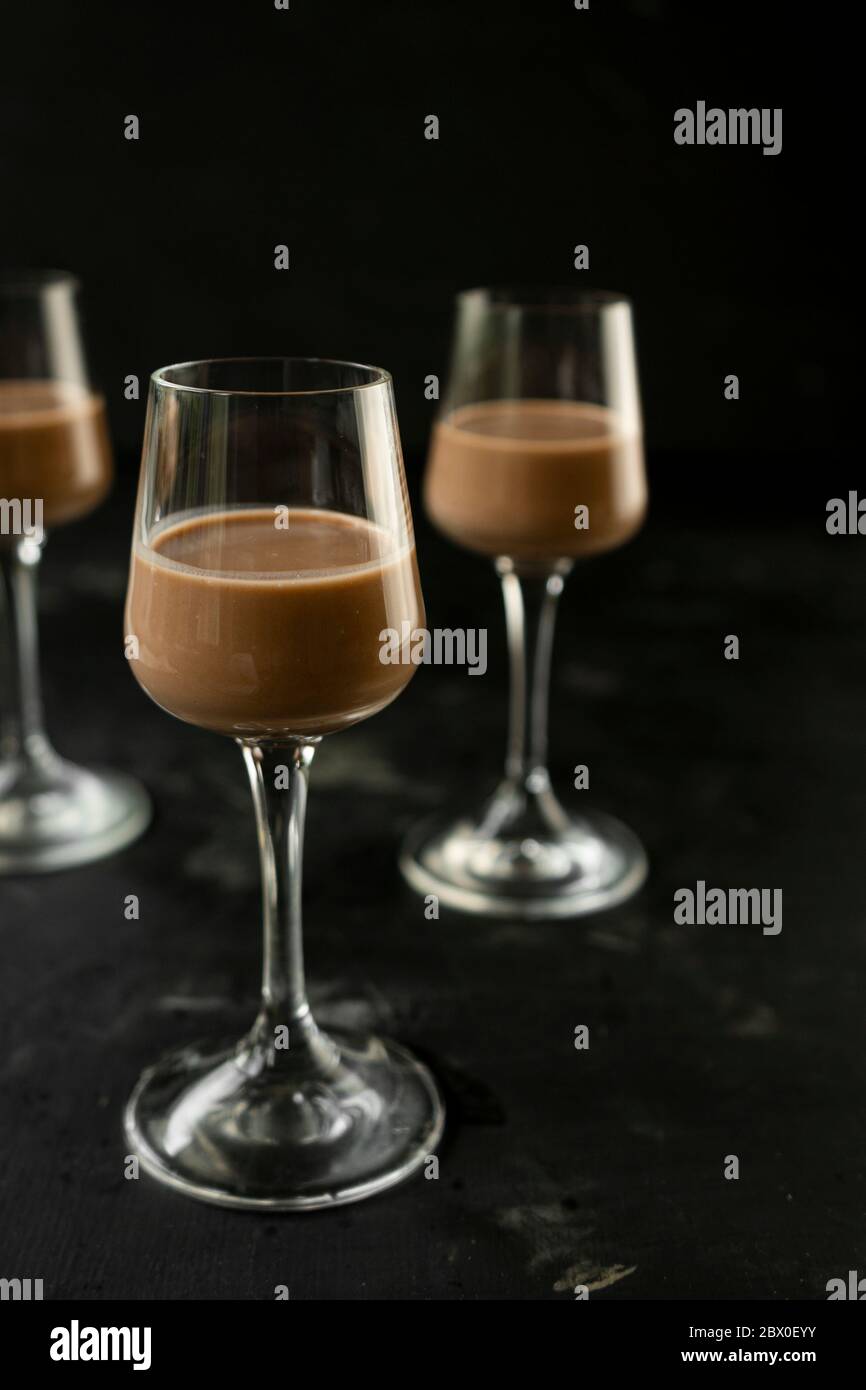 Selektiver Fokus: Schokolade und Kaffeelikör in einem hohen Stapel auf einem dunklen Tisch Stockfoto