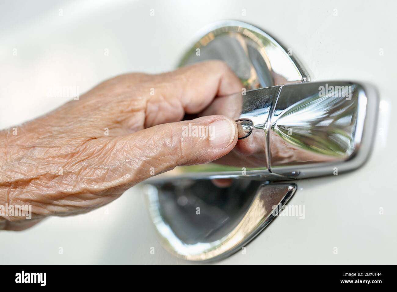 Ältere Frau zum Öffnen der Fahrzeugtür Stockfoto