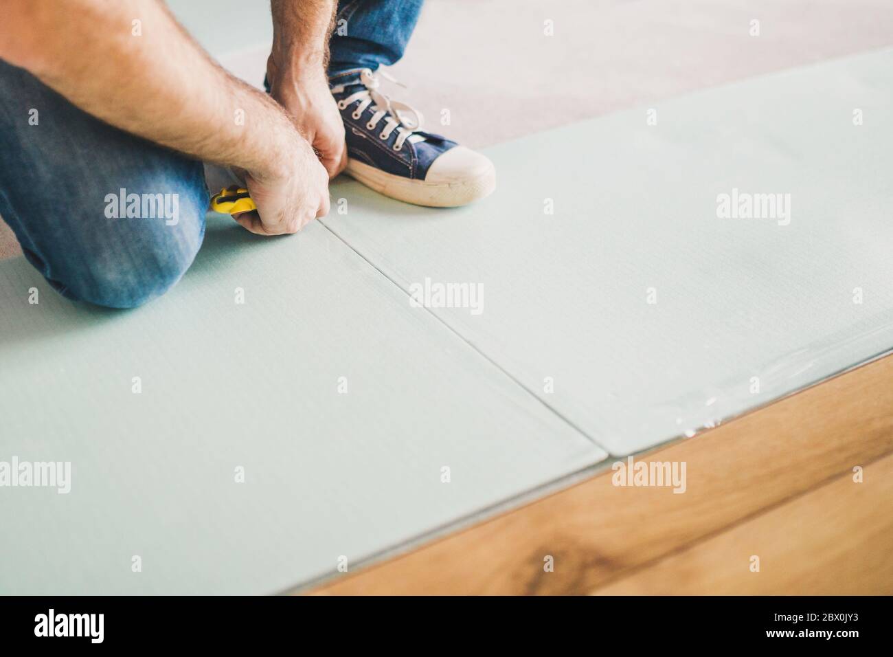 Bodentechnik - Verlegen eines schwimmenden Laminatbodens - umweltfreundliches Finishing-Material Stockfoto