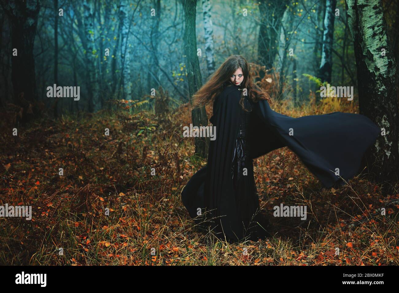 Geheimnisvolle Frau, die im magischen Wald spazierengeht. Fantasy und Gothic Stockfoto