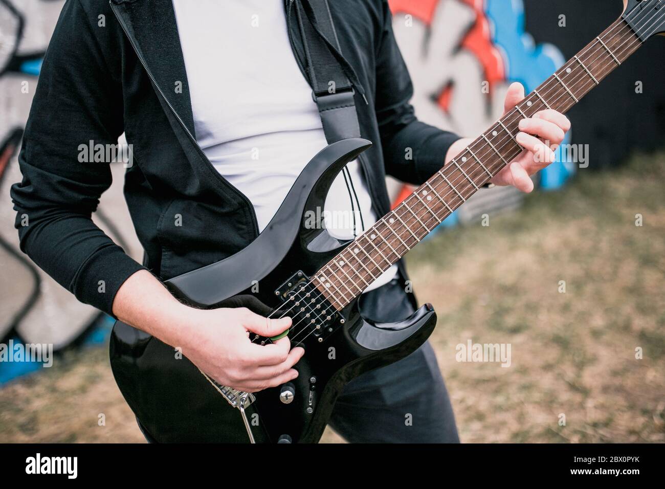 Mann mit schwarzer E-Gitarre im Freien - Blues Rock Musik Stockfoto
