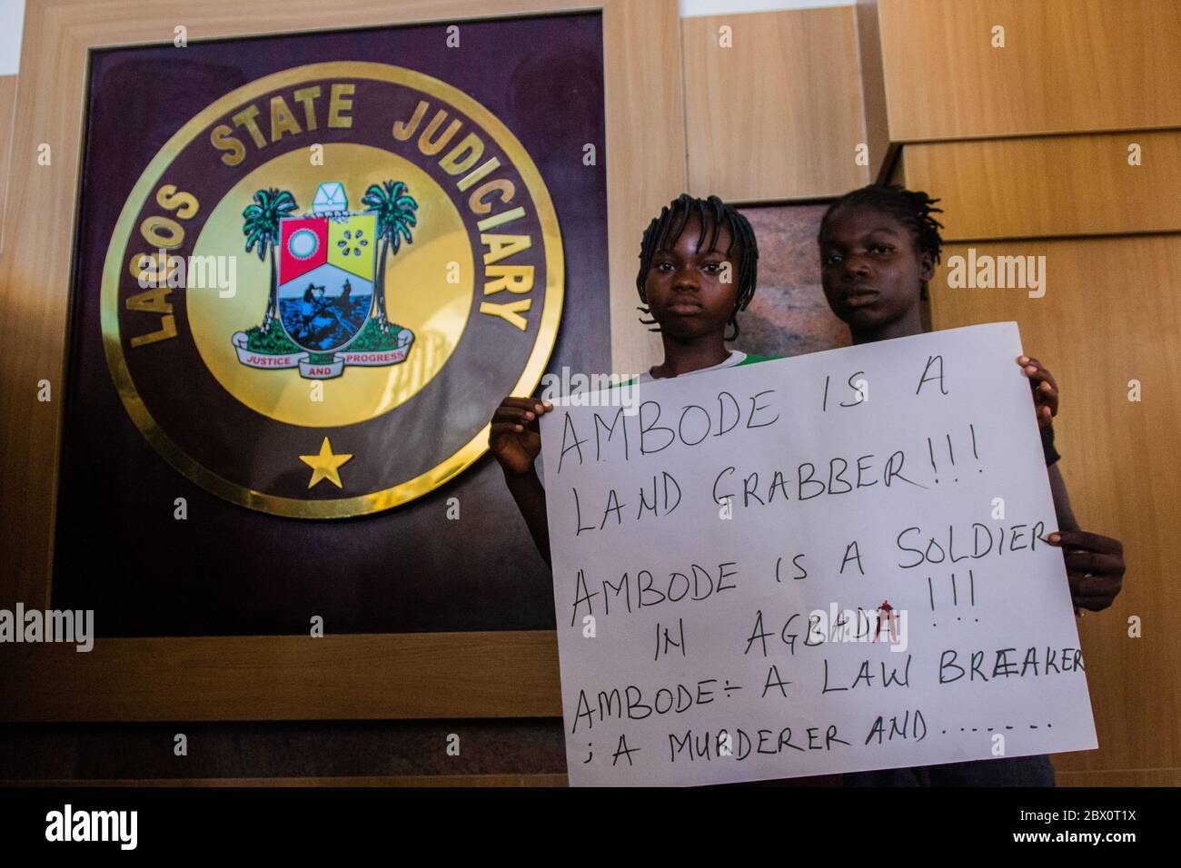 Lagos, Nigeria. Zwei Mädchen aus Otodo Gbame Plakate im Protest vor dem Gerichtssaal des Lagos State High Court. April 2017. Stockfoto
