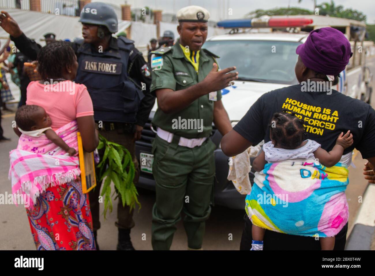 Lagos, Nigeria. Zwei Frauen aus dem Lagos waterfront Gemeinschaften stellen einige Polizisten zu verhindern, dass zunehmend Eingang in die Prämisse des Lagos State Government House. Mehr als 6 Monate nach dem Urteil des Gerichtshofs hat der Staat noch seine Versprechen zu erfüllen und die gerichtliche Anordnungen gehorchen. Otodo Gbame und andere waterfront Gemeinschaften inszenierte einen friedlichen Protest gegen die Regierung. Der Protest abgerechnet wurde für drei Nächte und Tage, die Nigeria Polizei auf die Demonstranten 12.28 gesprungen bin am 16. November und 158 Demonstranten festgenommen. Sie wurden später zu sig Stockfoto