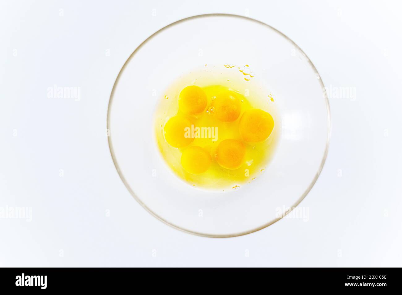 Helle zerbrochene Eier in einer Glasplatte auf einem weißen Tabelle Stockfoto