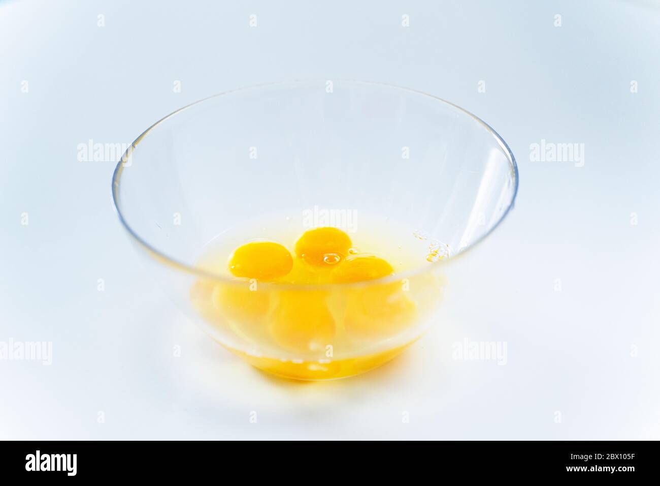 Helle zerbrochene Eier in einer Glasplatte auf einem weißen Tabelle Stockfoto