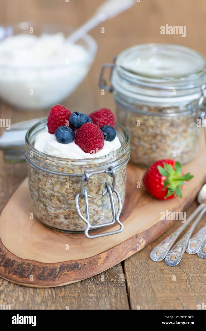 Hafer-Frühstückstöpfe mit griechischem Joghurt, Heidelbeeren und Himbeeren. Stockfoto