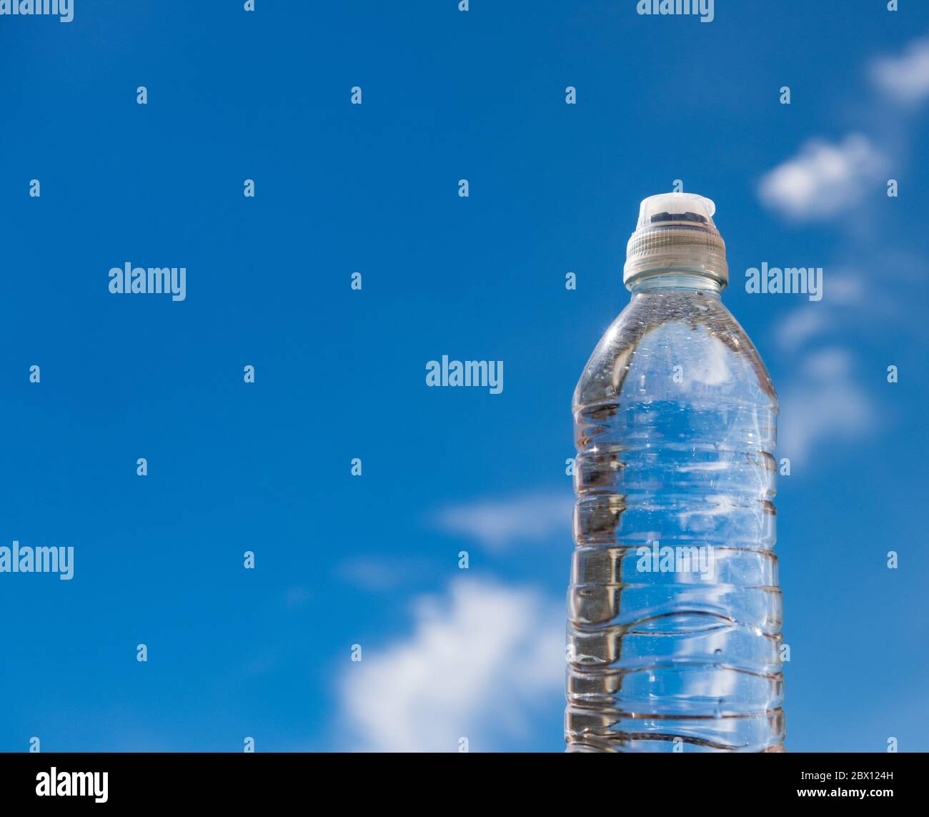 Eine Plastikflasche mit Trinkwasser vor einem blauen Himmel Stockfoto