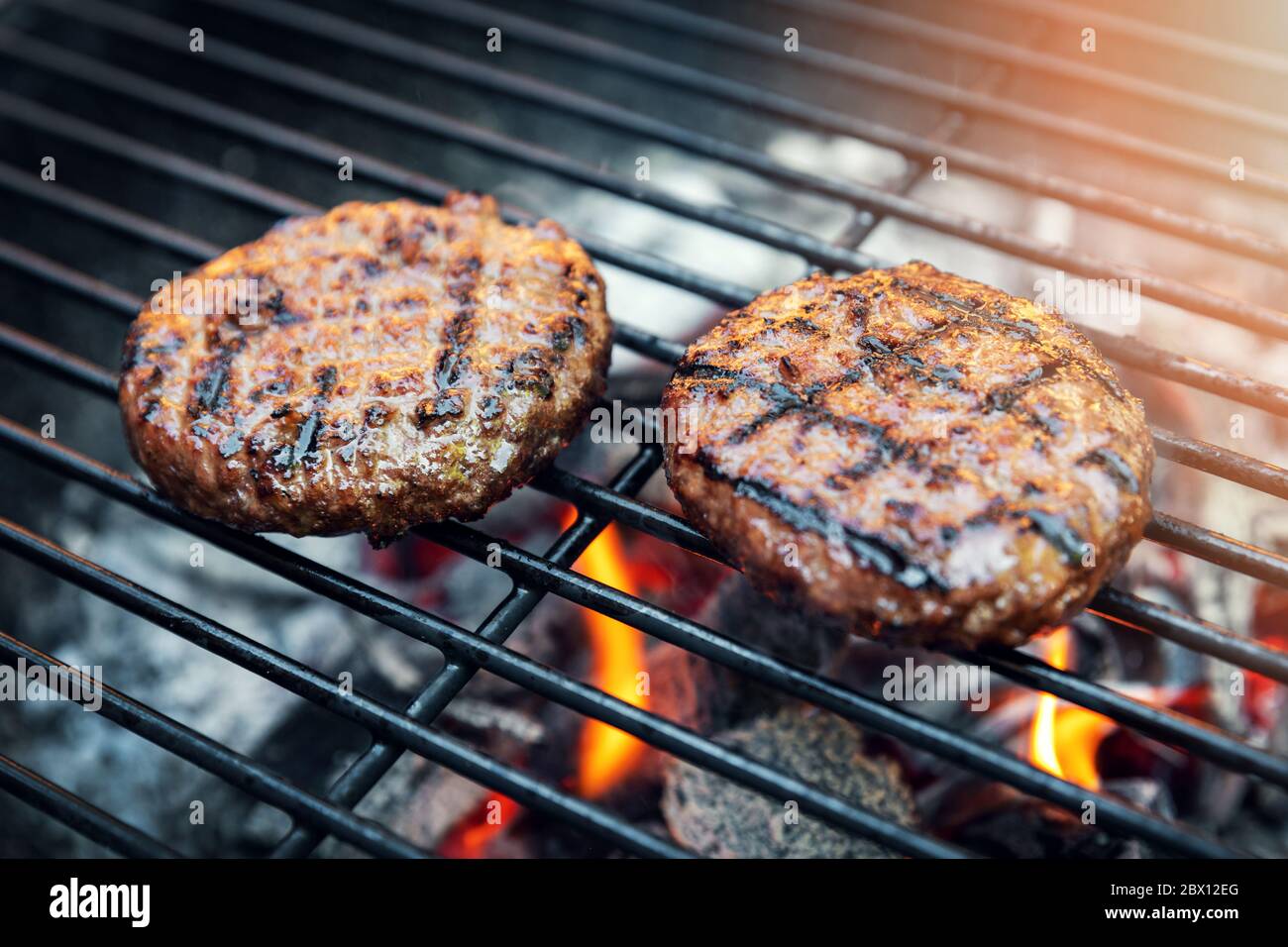 Rindfleisch Burger Fleisch Kochen auf Holzkohlegrill im Freien Stockfoto