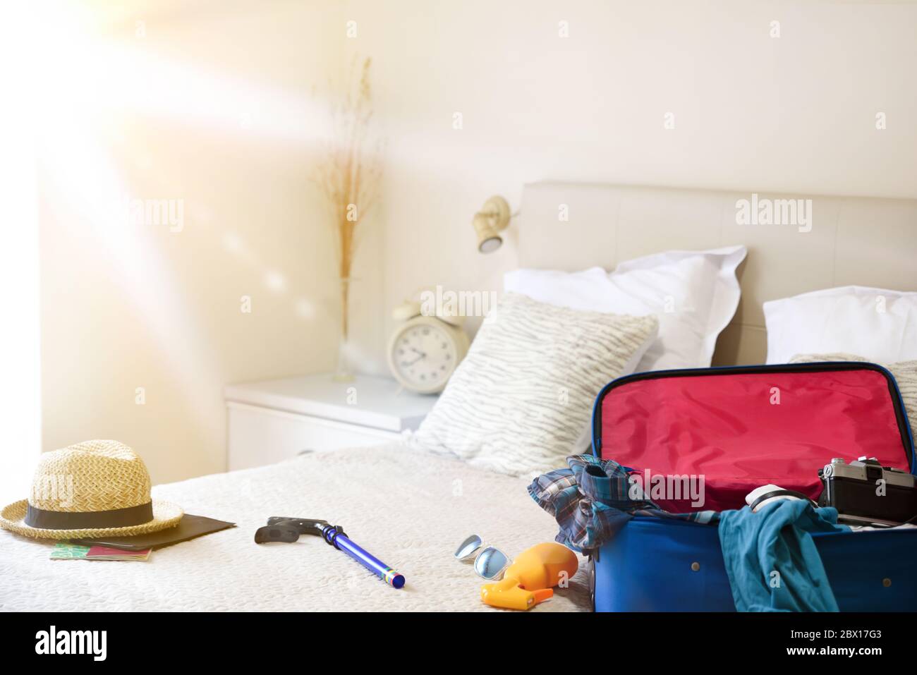 Sommerurlaub Reise-Accessoires auf dem Bett und Maske für Urlaubsreisen in Coronavirus Saison im Schlafzimmer vorbereitet. Urlaubsreisekonzept. Draufsicht. Stockfoto
