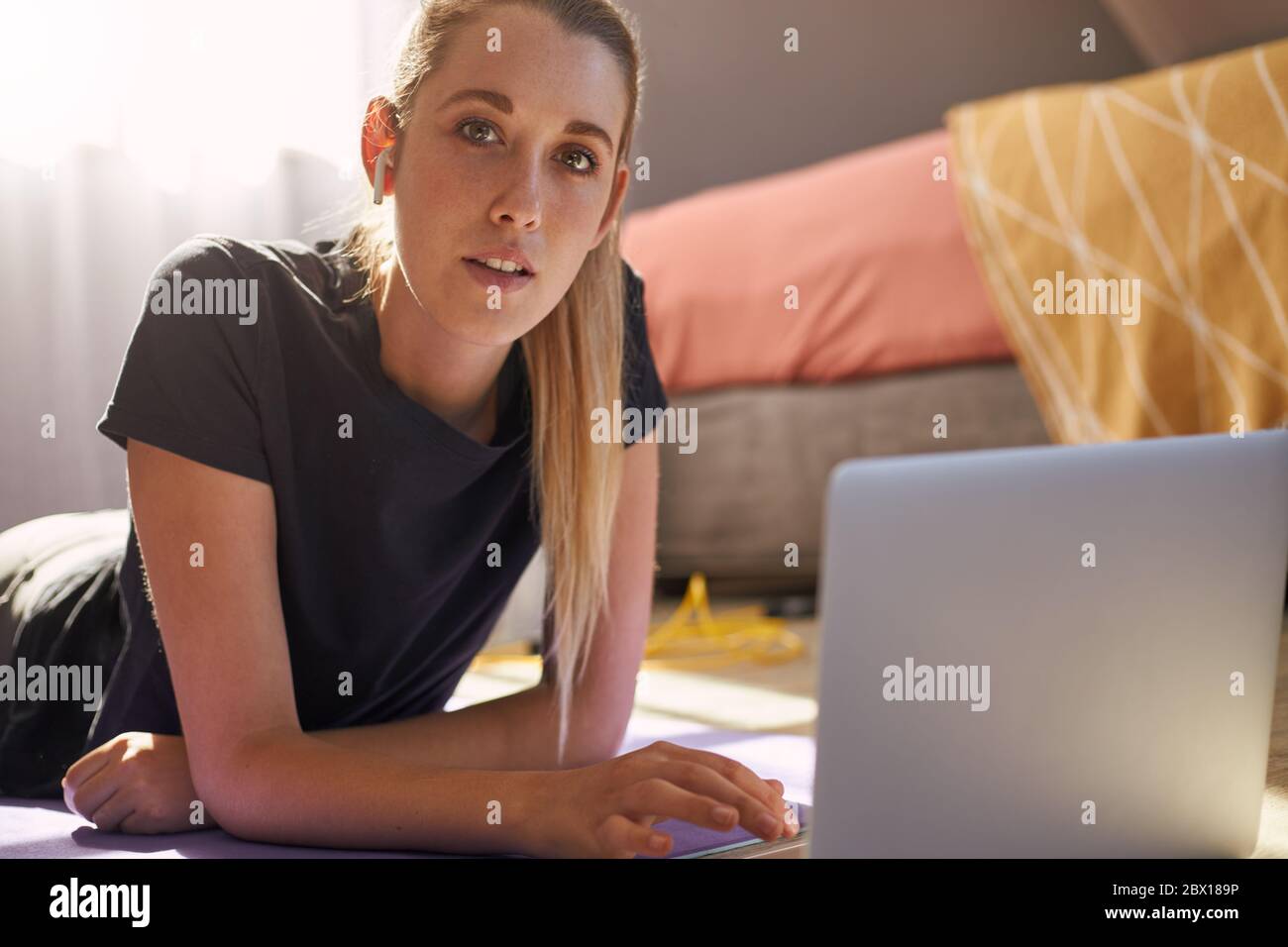 Junge Frau, die an Online-Fitness-Klasse vor dem Laptop. Stockfoto