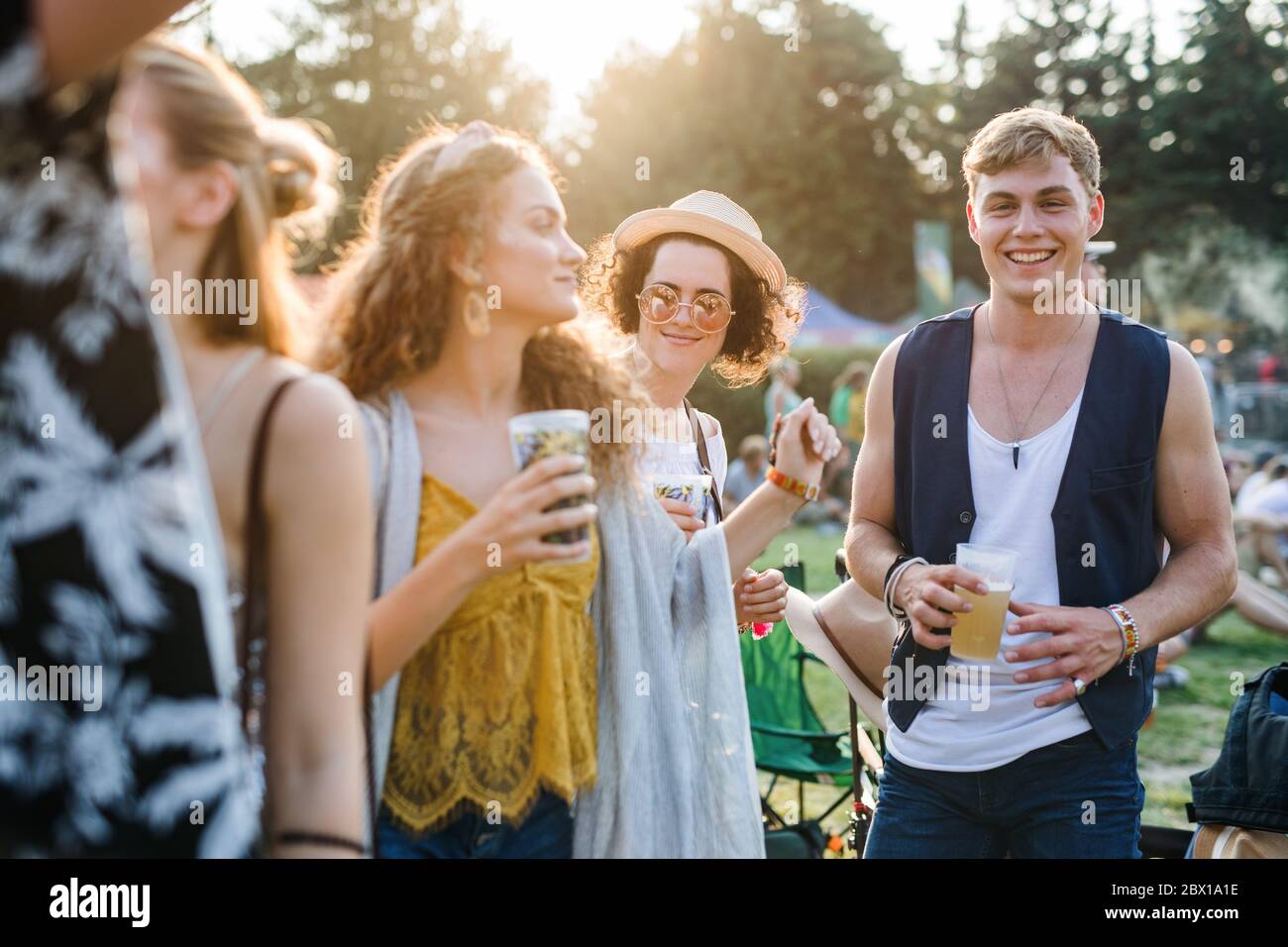 Gruppe von jungen Freunden mit Getränken beim Sommerfest, stehend. Stockfoto