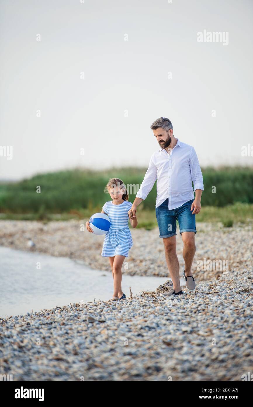 Reifer Vater und kleine Tochter auf einem Urlaub am See spazieren. Stockfoto